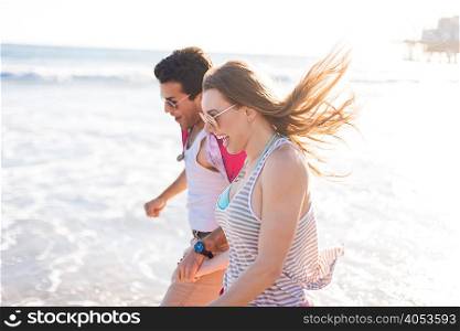 Young couple paddling in sea, Santa Monica, California, USA