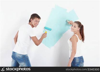 Young couple paint the walls green