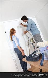 Young couple painting walls of their new house