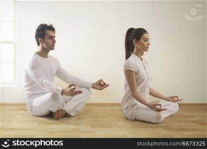 Young couple performing yoga