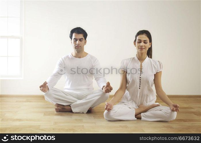 Young couple performing yoga
