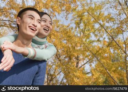 Young couple piggyback in park