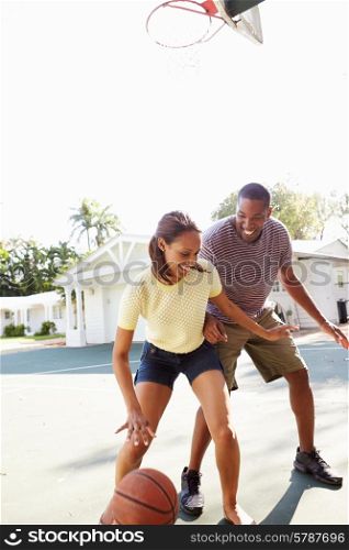Young Couple Playing Basketball Together