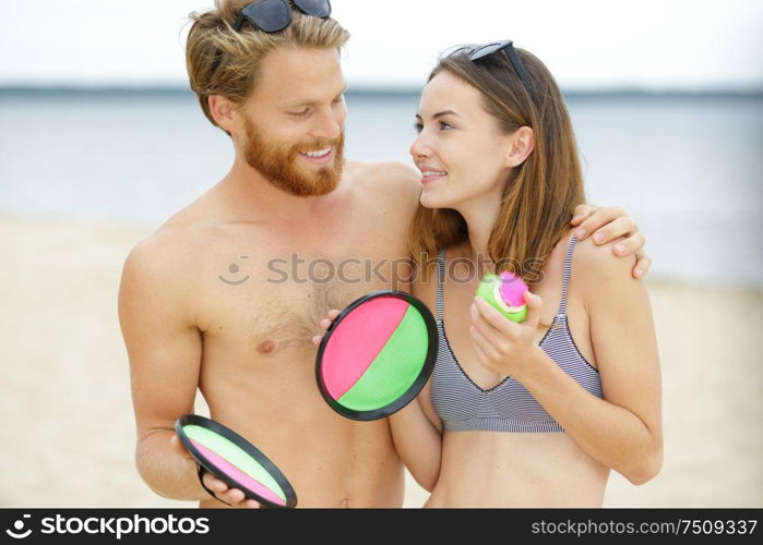 young couple playing beach tennis