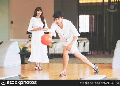 Young couple playing bowling at the club. Sport and recreation lifestyle.. Young couple playing bowling at the sport club.