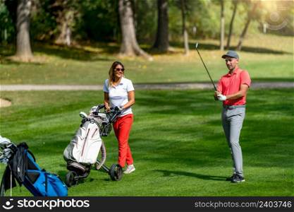 Young couple playing golf on a beautiful summer day