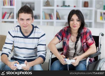 young couple playing video games at home girl in wheelchair