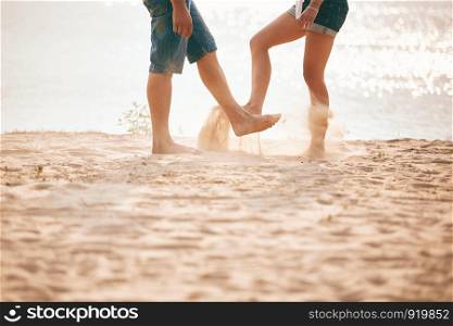 young couple playing with sand. Summer lifestyle. young couple playing with sand. Summer lifestyle. feet in the sand on the beach