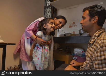 Young couple playing with their little daughter in the kitchen