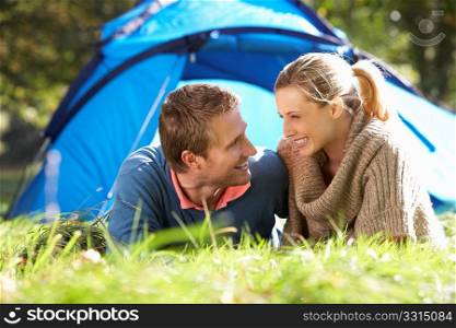 Young couple posing outside of tent