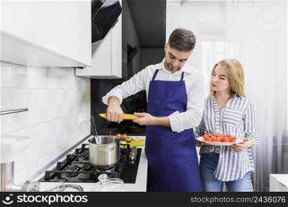 young couple putting spaghetti pot with boiled water