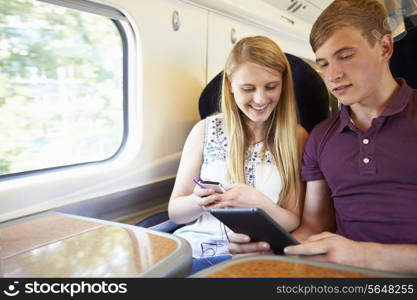 Young Couple Reading E Book On Train Journey