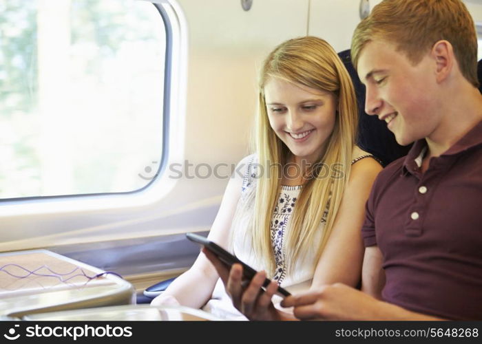 Young Couple Reading E Book On Train Journey