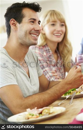 Young Couple Relaxing At Dinner Party