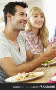 Young Couple Relaxing At Dinner Party