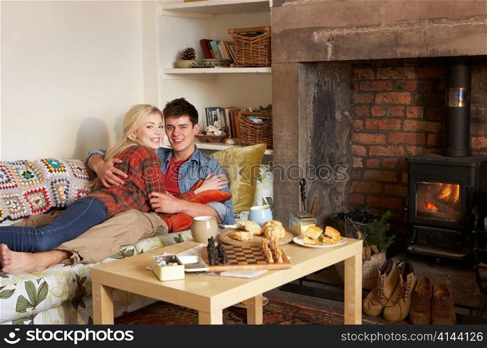 Young couple relaxing by fire