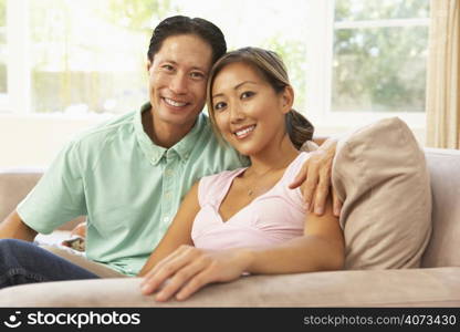 Young Couple Relaxing On Sofa At Home