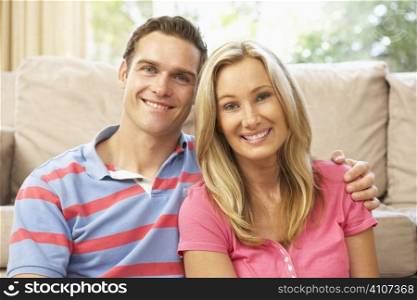 Young Couple Relaxing On Sofa At Home