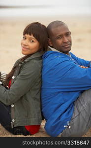 Young Couple Relaxing On Winter Beach Holiday