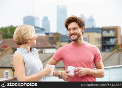 Young Couple Relaxing With Coffee On Roof Terrace