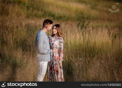 young couple resting in nature in a field. couple at sunset.. young couple resting in nature in a field. couple at sunset