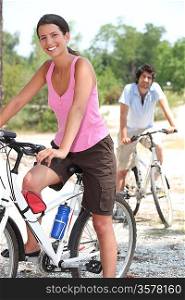 Young couple riding bikes in the countryside