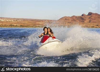Young couple riding jetski on lake