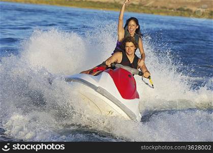 Young couple riding jetski on lake