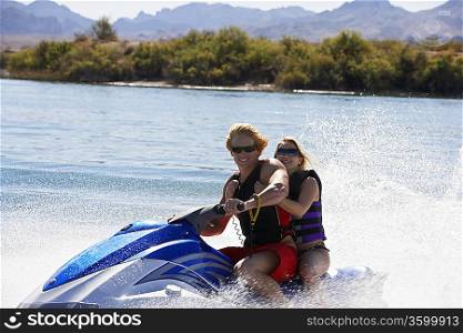 Young couple riding jetski on lake portrait