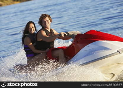 Young couple riding jetski on lake portrait