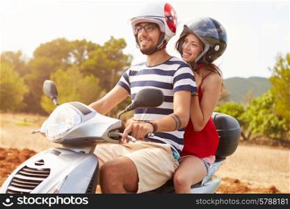 Young Couple Riding Motor Scooter Along Country Road
