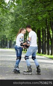 Young couple roller-skating in the park