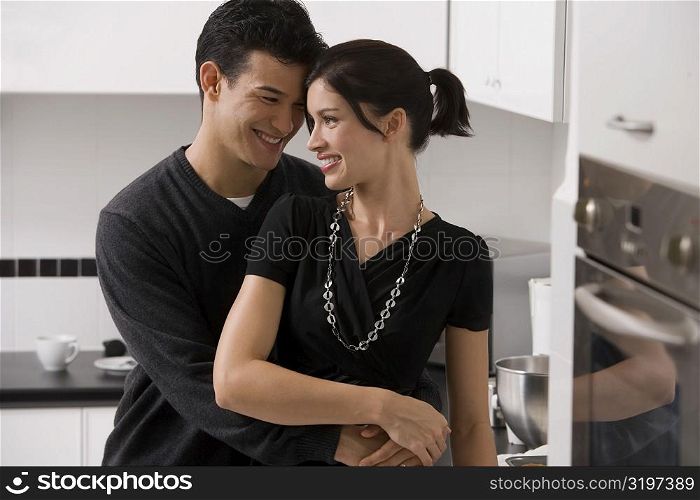 Young couple romancing in the kitchen