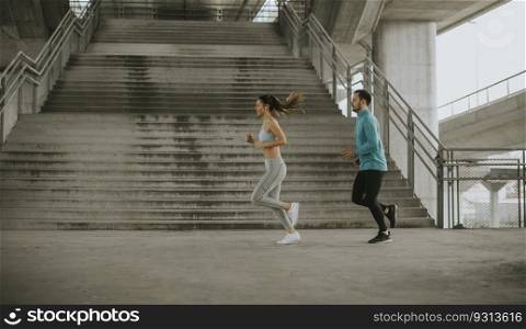 Young couple running in the urban enviroment
