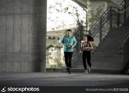 Young couple running in urban environment at sunny day