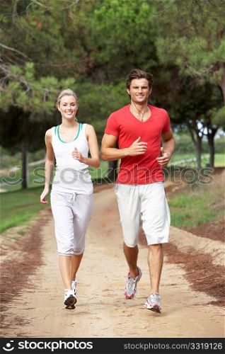 Young couple running through park