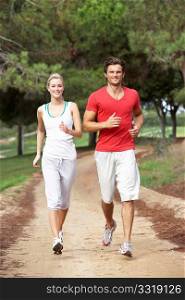 Young couple running through park