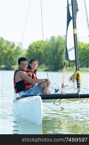 young couple sailing a catamaran