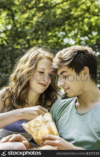Young couple sharing bag of food