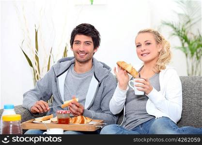 Young couple sharing breakfast in the lounge