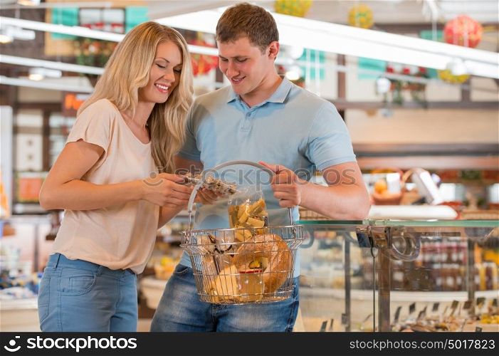 Young couple shopping at supermarket - filling cart