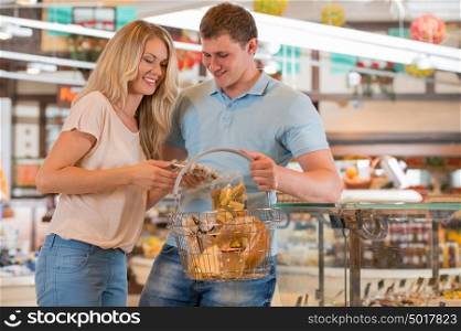 Young couple shopping at supermarket - filling cart
