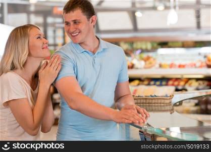 Young couple shopping at supermarket - having fun together
