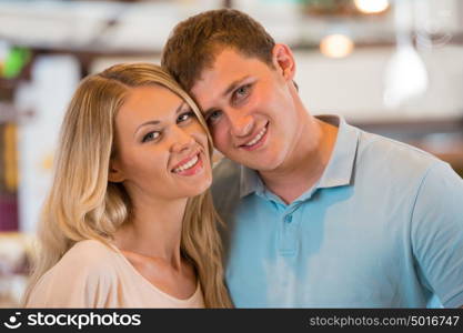 Young couple shopping at supermarket - hugging together