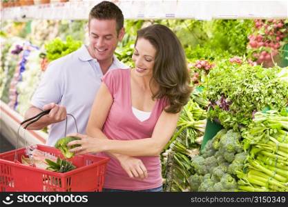 Young couple shopping for broccoli at a grocery store
