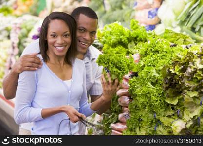 Young couple shopping for lettuce at a grocery store