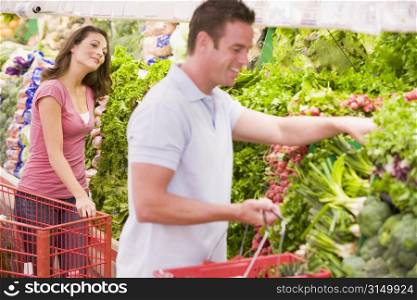 Young couple shopping for vegetables at a grocery store
