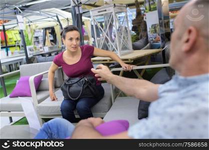 young couple shopping man smiling at woman on sofa