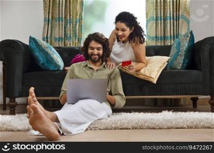 Young couple shopping online through laptop using credit card at home