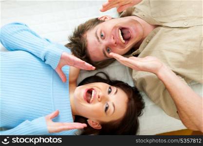 Young couple shouting through megaphone shaped hands